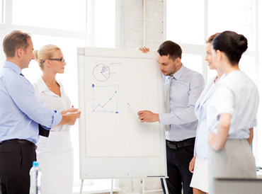 4 Personen stehen um eine flipchart